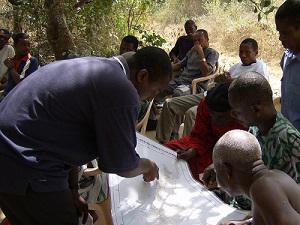 Edem discussing a map with some farmers.