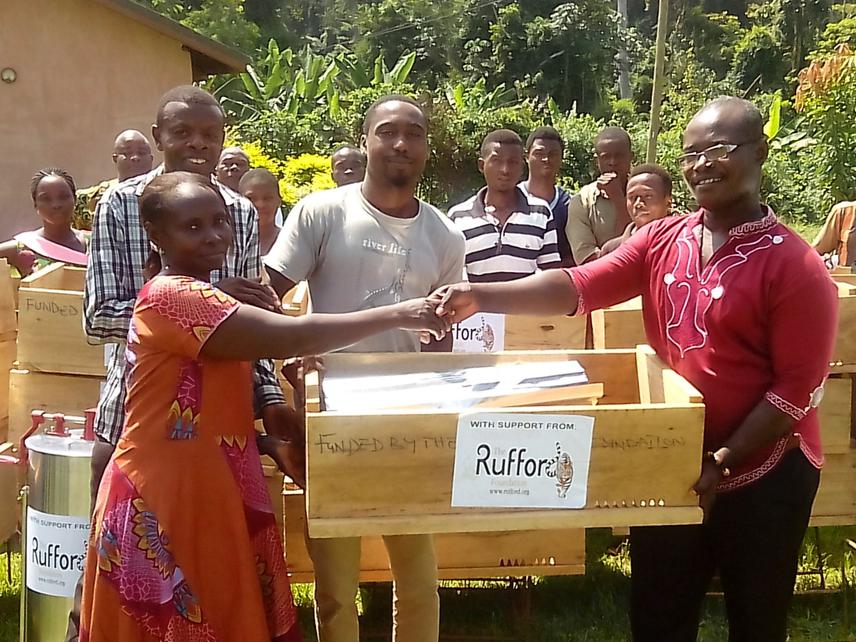 A beehive being handed over by Mr. Richard Boakye to Mary Arthur, a project beneficiary.