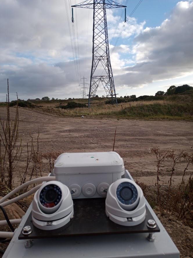 Prototype in the field. View of the cameras set up in the field, under the cables of the power line, with the cameras looking up.