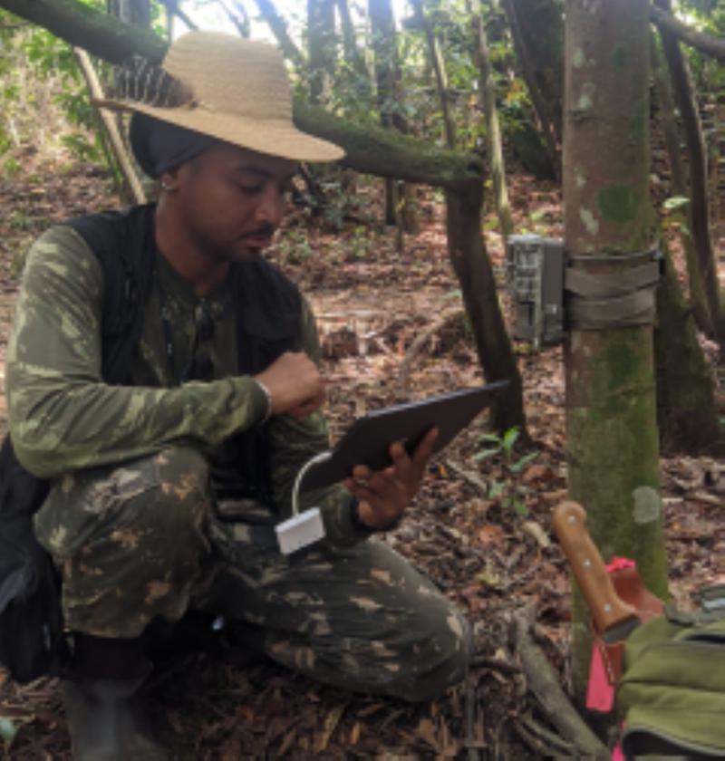 Filipe Guimarães Lima using a tablet to check out the records and camera trap functioning in the field.