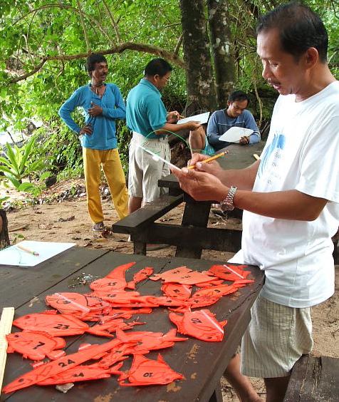 A community participant reviews fish sizes during the marine assessment training.